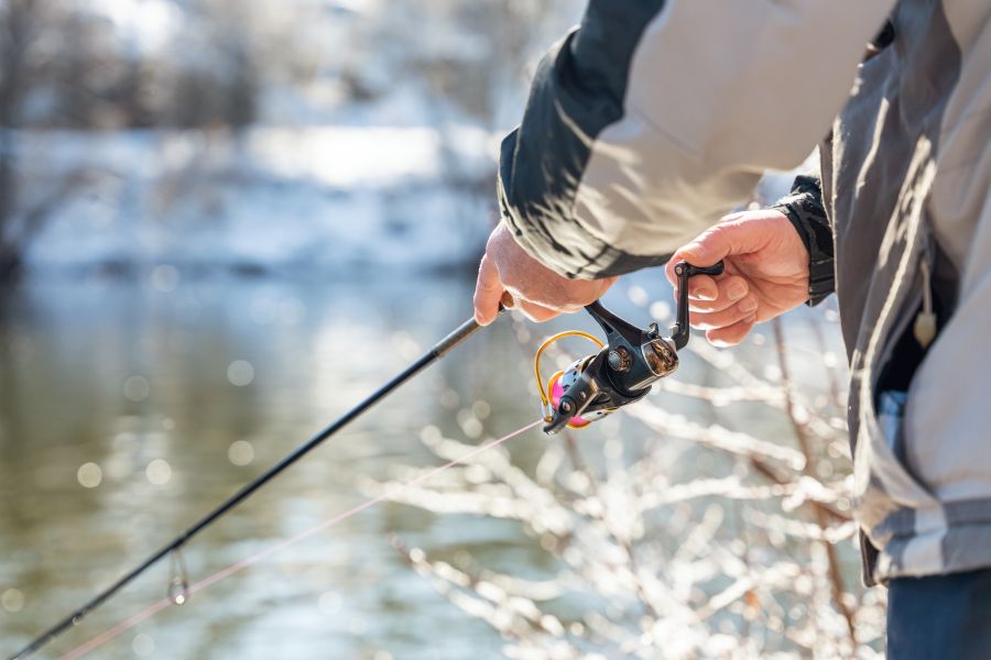 Pisciculture De Monchel : Fishing On The River In Winter, The Fisherman Holds A Fishing Rod In His Hands And Spins The Reel